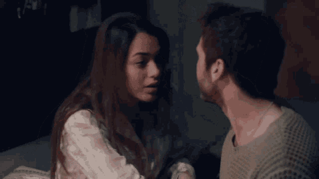 a man and a woman are looking at each other with their eyes closed
