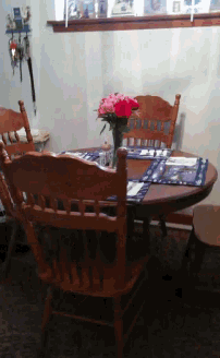 a dining room table with a vase of flowers on top