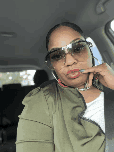 a woman wearing sunglasses and a green jacket