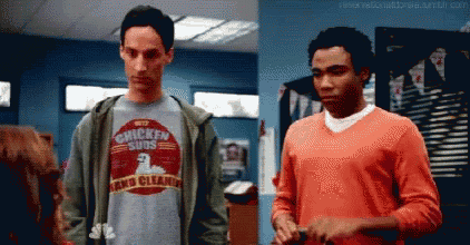 a man wearing a chicken subs shirt is standing next to another man .