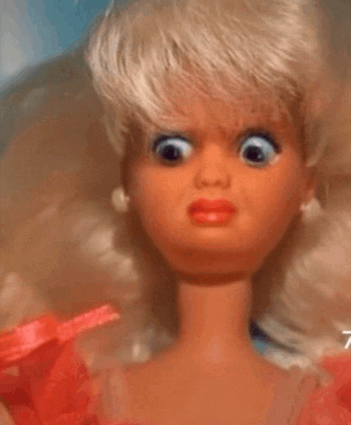 a close up of a barbie doll with big eyes and a red dress .