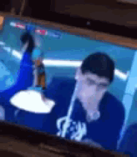 a blurry picture of a man eating a hamburger on a tv screen .