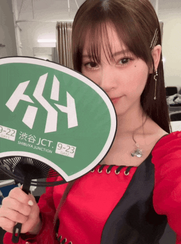 a girl is holding a fan that says jct 9-23