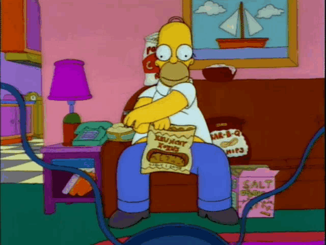homer simpson is sitting on a couch eating a bag of crunchy xtreme chips