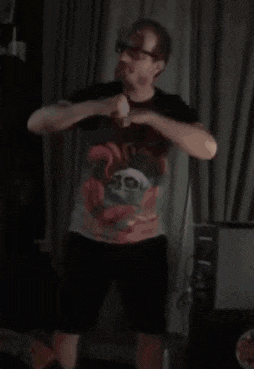 a man in a t-shirt and shorts is dancing in a room .