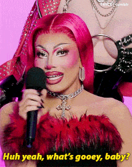 a woman with pink hair is holding a microphone and saying huh yeah what 's gooey baby .