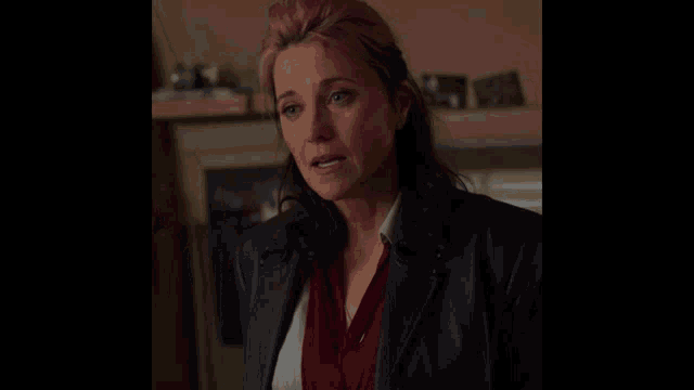 a woman with pink hair is wearing a black jacket and a red sweater
