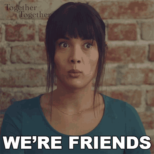 a woman in a blue shirt says we 're friends in front of a brick wall