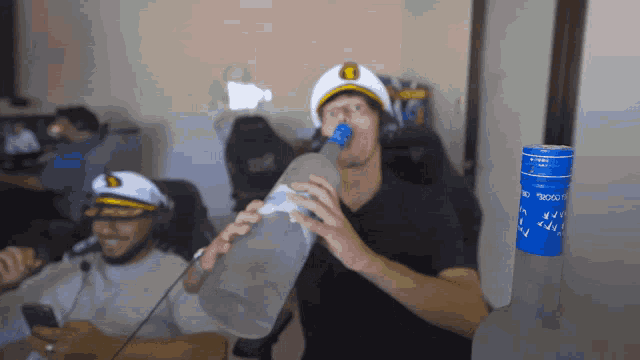 a man drinking from a bottle with a blue label that says ketel one