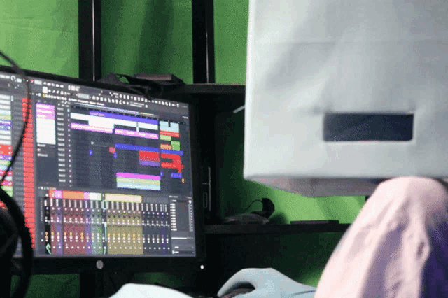 a person sitting in front of a computer with a box on their head that says ' a ' on the screen