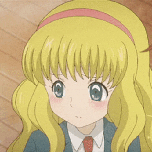 a girl with blonde hair and blue eyes is holding a candy in her hand .