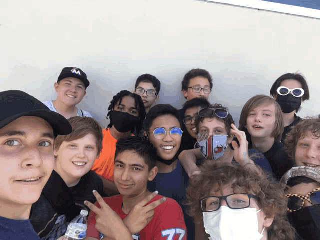 a group of young people are posing for a picture with one wearing a shirt with the number 77 on it