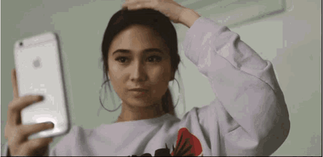 a woman is taking a picture of herself with her phone