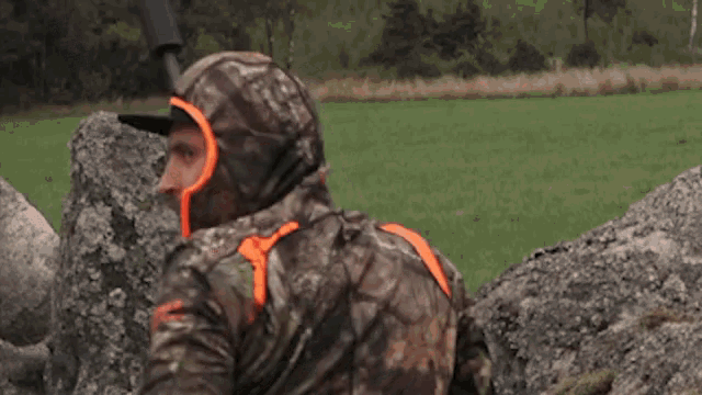 a man in a camo jacket holding a gun