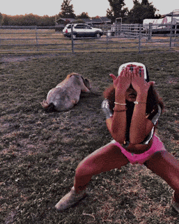 a woman covering her eyes with her hands while a horse lays on the ground