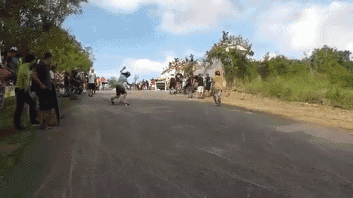 a group of people are riding skateboards down a hill
