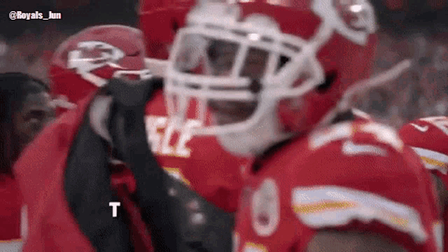 a football player wearing a helmet with the letter t on the bottom
