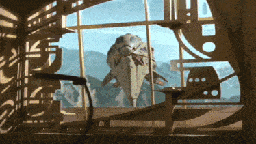 a model of a space ship is sitting in front of a window with mountains in the background