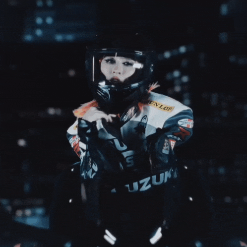 a woman wearing a dunlop helmet and a suzuki jacket