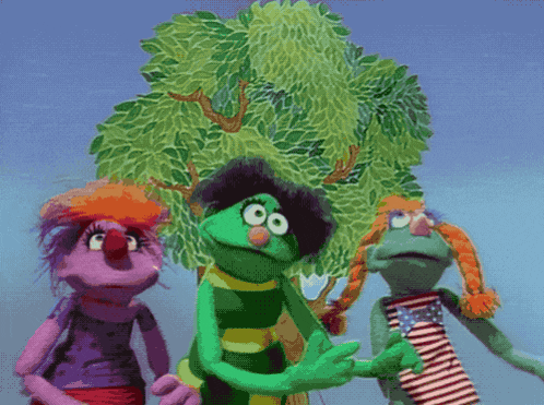 a group of sesame street characters standing in front of a tree