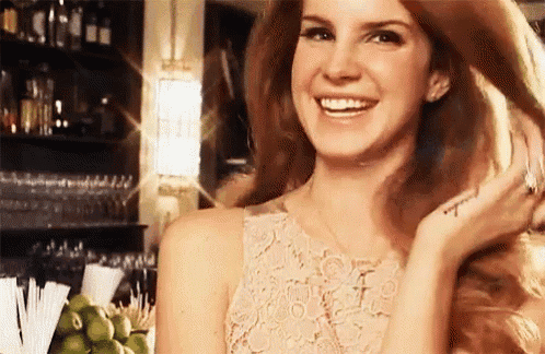 a woman in a lace dress is smiling and touching her hair .