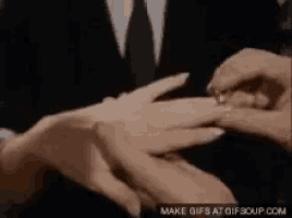 a man is putting a ring on a woman 's finger .