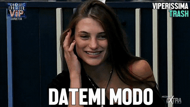 a woman is smiling and talking on a cell phone with the words datemi modo written above her