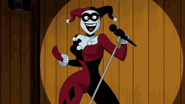 harley quinn is singing into a microphone and smiling