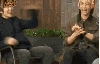 two men are sitting next to each other on a couch and making funny faces .