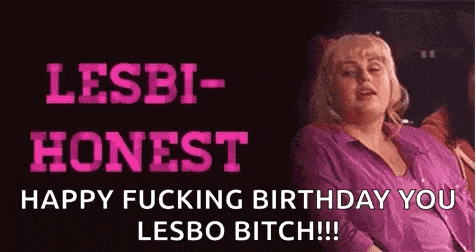 a woman in a pink shirt is sitting in front of a sign that says `` happy fucking birthday you lesbo bitch !! ''