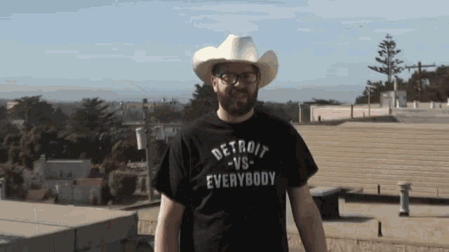 a man in a cowboy hat is wearing a detroit vs everybody shirt