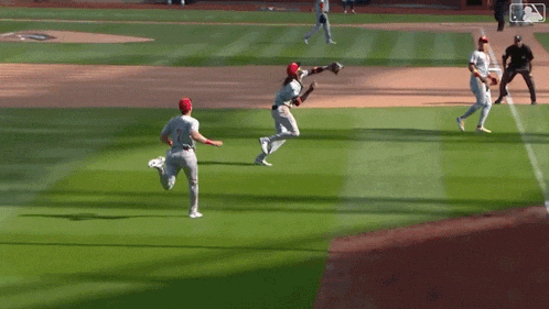 a baseball player catches a ball while another player watches