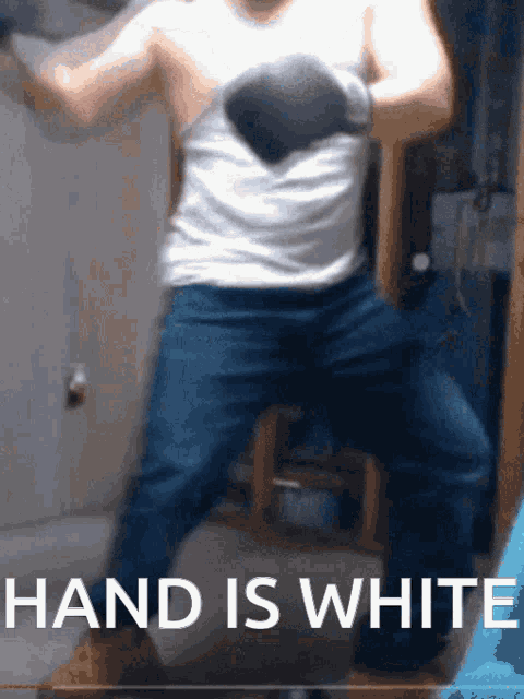 a man wearing boxing gloves stands in front of a sign that reads hand is white