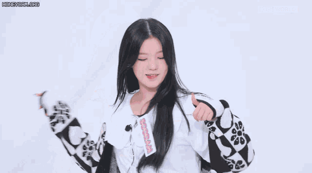 the girl is wearing a white shirt and a black and white jacket .