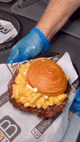a hamburger is being prepared on a plate that says burgers on it