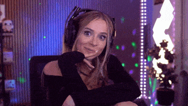 a woman wearing headphones is sitting in a dark room