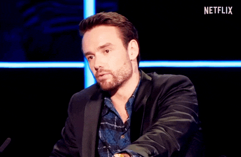 a man sitting in front of a microphone with a netflix logo behind him
