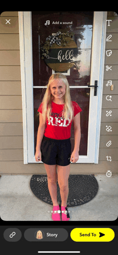 a girl wearing a red shirt and black shorts is standing in front of a door