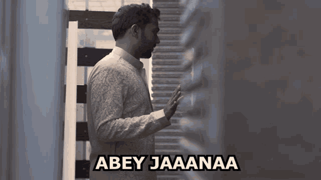 a man standing next to a wall with the words abey jaananaa written above him