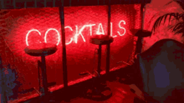 a neon sign that says cocktails is lit up in red