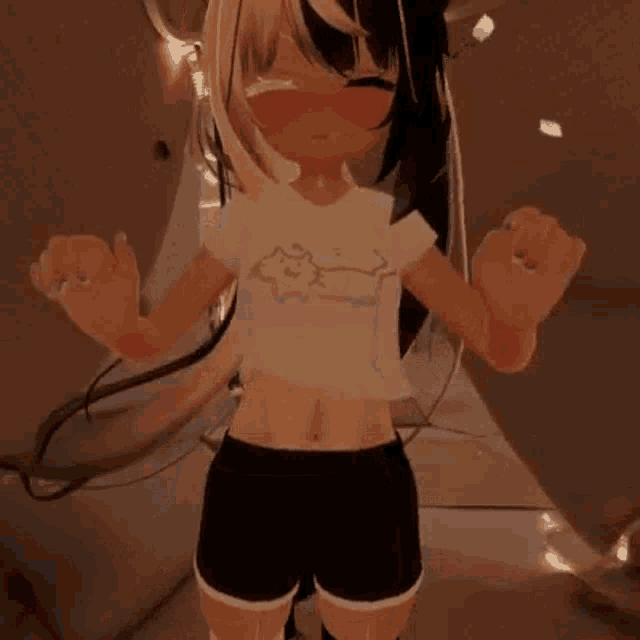 a girl in a crop top and shorts is standing in a room with her hands in the air .
