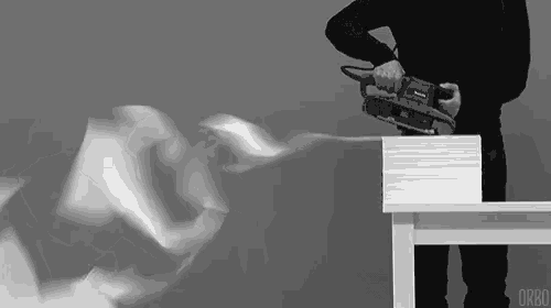 a black and white photo of a man using a makita saw