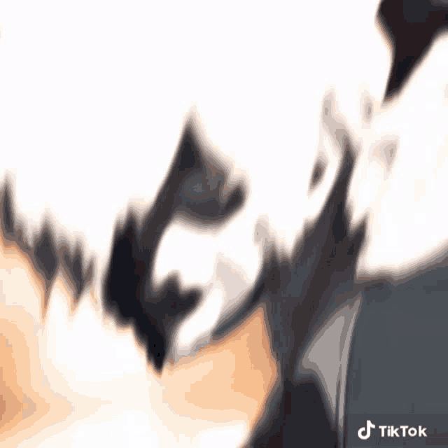 a blurred image of a person 's face with a tiktok logo in the corner