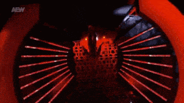 a woman is dancing on a stage in a dark room with red lights .