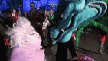 a blurry picture of a group of people standing around a giant statue of a dragon .