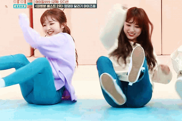 a girl in a purple sweater sits next to another girl in blue pants