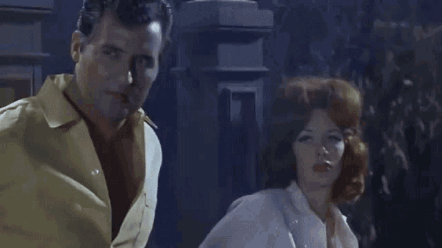 a man and a woman with red hair are standing next to each other
