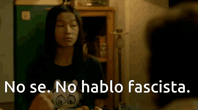 a woman sitting at a table with the words no se no hablo fascista