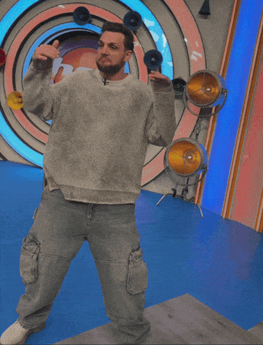 a man in a grey sweater and jeans is dancing