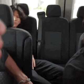 a woman sits in the back seat of a bus